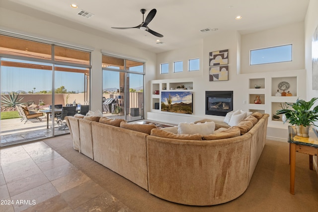 living room featuring built in shelves and ceiling fan