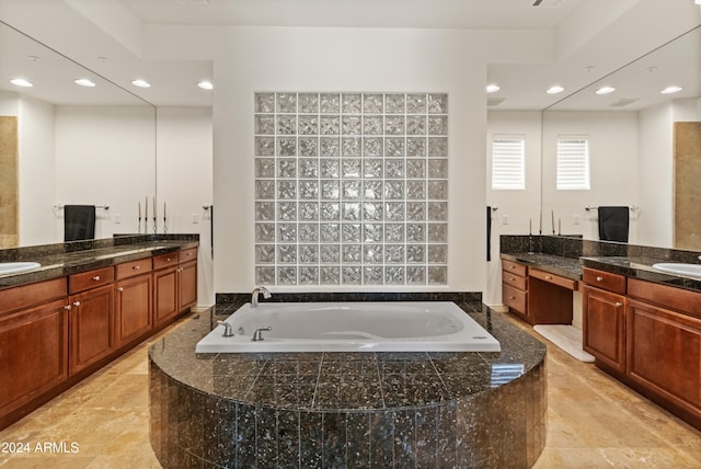 bathroom with vanity and a relaxing tiled tub