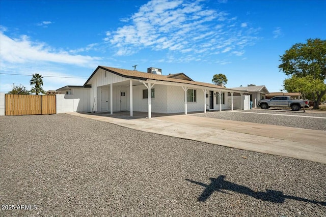 3846 W Cavalier Dr, Phoenix, AZ 85019 - view of front of home featuring concrete driveway, a carport, a gate, board and batten siding, and fence
