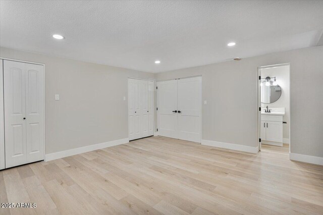 3846 W Cavalier Dr, Phoenix, AZ 85019 - unfurnished bedroom with light wood-style flooring, two closets, baseboards, and recessed lighting