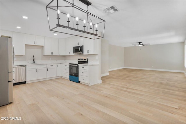 3846 W Cavalier Dr, Phoenix, AZ 85019 - kitchen featuring light wood-type flooring, appliances with stainless steel finishes, baseboards, and visible vents