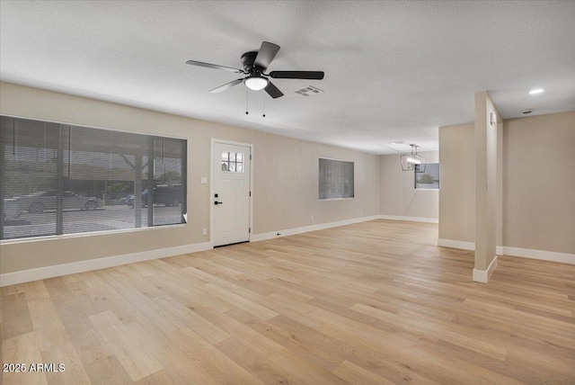 3846 W Cavalier Dr, Phoenix, AZ 85019 - interior space featuring baseboards, a textured ceiling, light wood-style floors, visible vents, and ceiling fan with notable chandelier