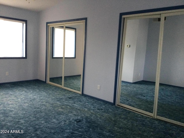 unfurnished bedroom with dark colored carpet