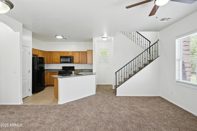 2109 E Fraktur Rd, Phoenix, AZ 85040 - kitchen with black appliances, light carpet, brown cabinets, a ceiling fan, and dark countertops