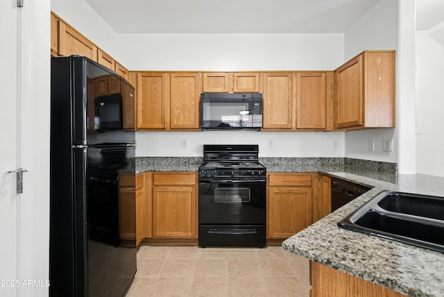 2109 E Fraktur Rd, Phoenix, AZ 85040 - kitchen featuring black appliances, brown cabinets, and dark stone countertops