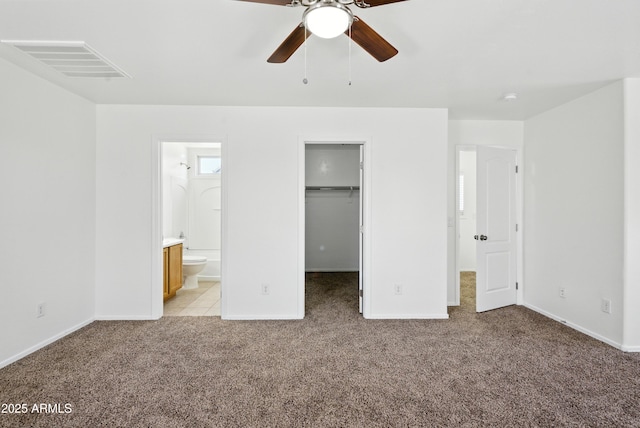 2109 E Fraktur Rd, Phoenix, AZ 85040 - unfurnished bedroom featuring light colored carpet, a walk in closet, ensuite bath, a closet, and a ceiling fan