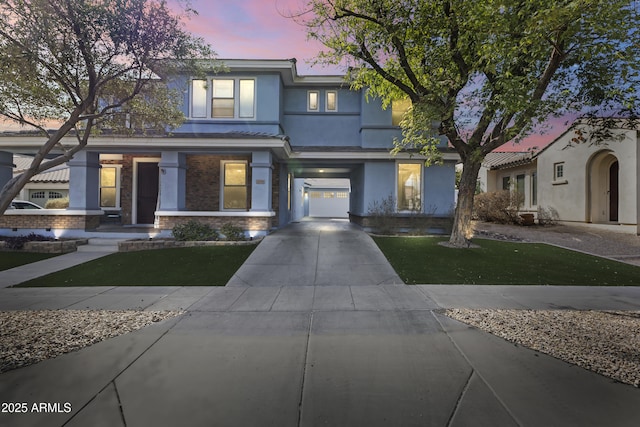 view of front of property with a front yard, concrete driveway, and stucco siding