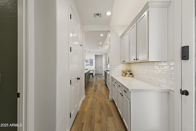 corridor featuring recessed lighting, visible vents, and light wood-style flooring