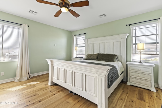 bedroom featuring light wood-type flooring, visible vents, ceiling fan, and baseboards