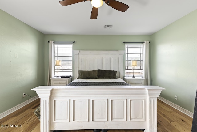 bedroom with multiple windows, wood finished floors, and visible vents