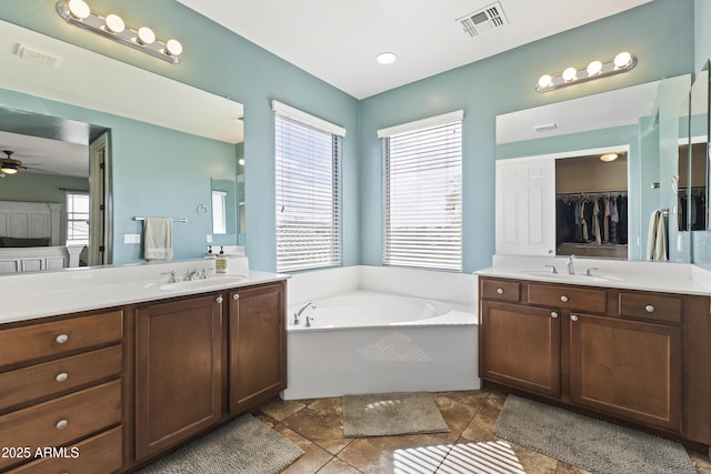 full bathroom with two vanities, a sink, and visible vents