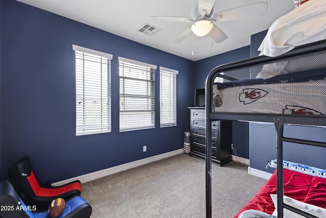 carpeted bedroom with a ceiling fan, visible vents, and baseboards