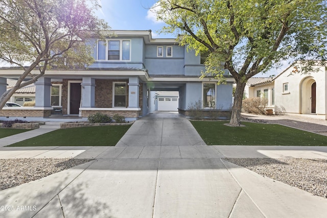 view of front of house with a garage, concrete driveway, a front yard, and stucco siding