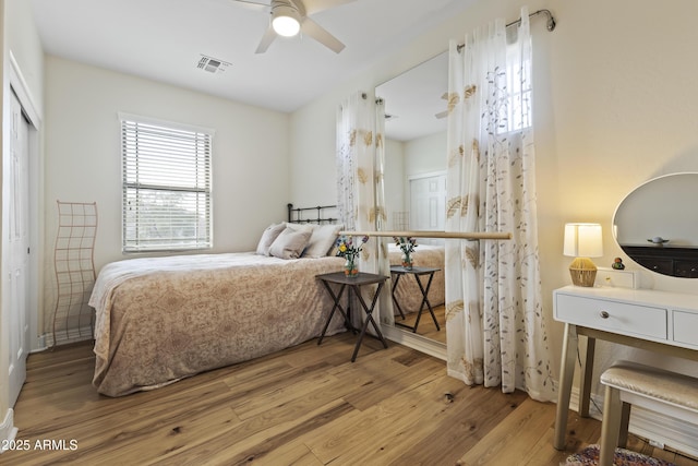 bedroom featuring wood finished floors, visible vents, and a ceiling fan