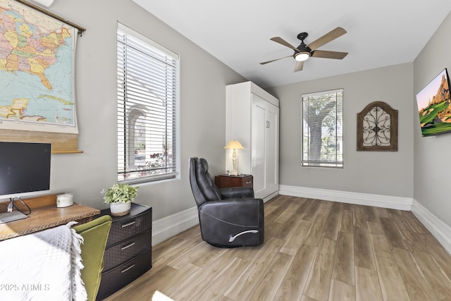 sitting room featuring a ceiling fan, baseboards, and wood finished floors