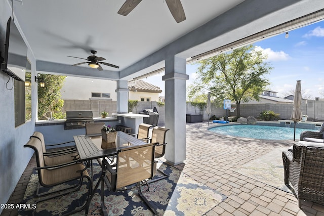 view of patio with a fenced in pool, outdoor dining area, an outdoor kitchen, area for grilling, and a fenced backyard