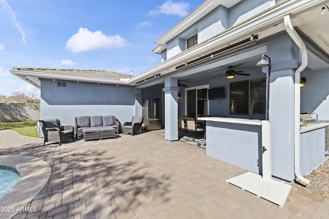 view of patio with a ceiling fan and an outdoor living space