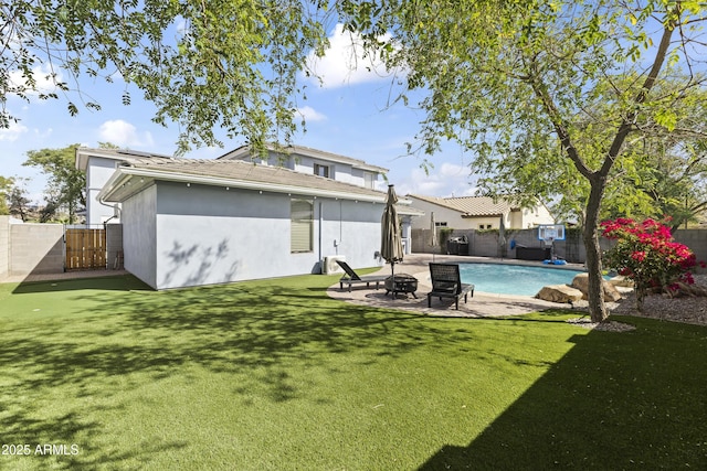 back of property with an outdoor fire pit, a fenced backyard, a lawn, and a patio