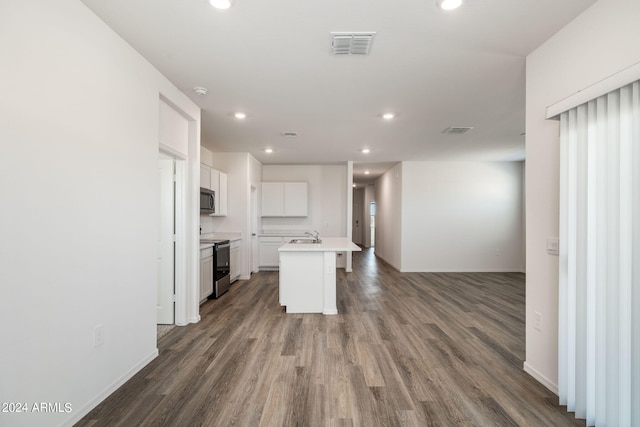 kitchen featuring sink, dark hardwood / wood-style floors, an island with sink, appliances with stainless steel finishes, and white cabinetry