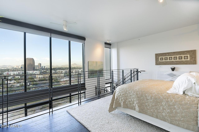 bedroom featuring wood-type flooring, expansive windows, and ceiling fan