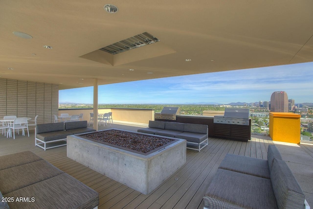 deck featuring grilling area and an outdoor living space with a fire pit