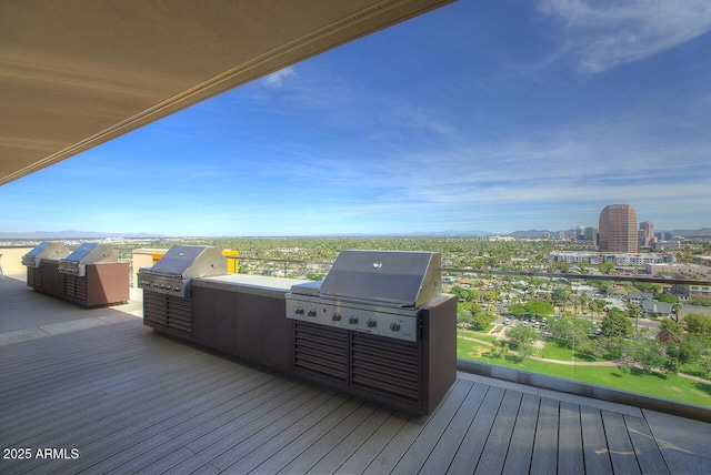 wooden deck featuring an outdoor kitchen and a grill