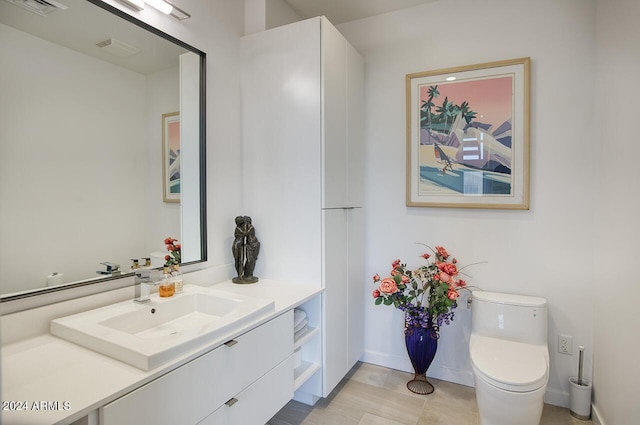 bathroom with tile patterned flooring, vanity, and toilet