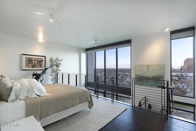 bedroom featuring ceiling fan, expansive windows, and dark wood-type flooring