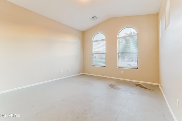 empty room featuring concrete floors and lofted ceiling