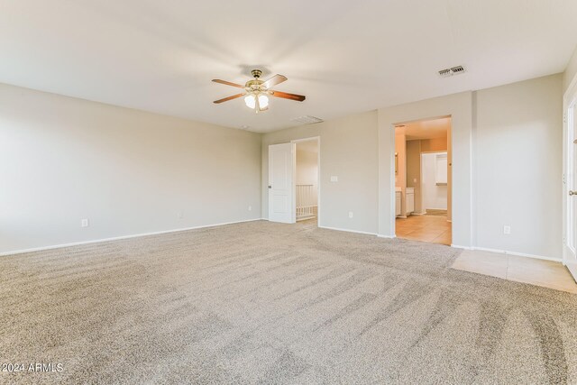 spare room featuring light colored carpet and ceiling fan