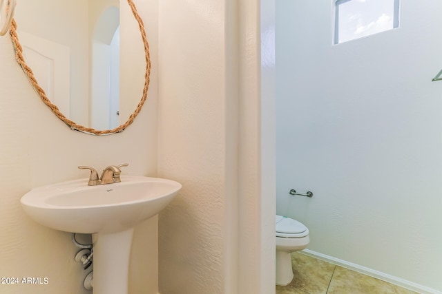 bathroom featuring toilet, sink, and tile patterned floors