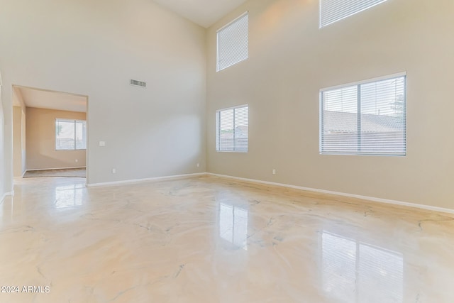 unfurnished room featuring a high ceiling and plenty of natural light