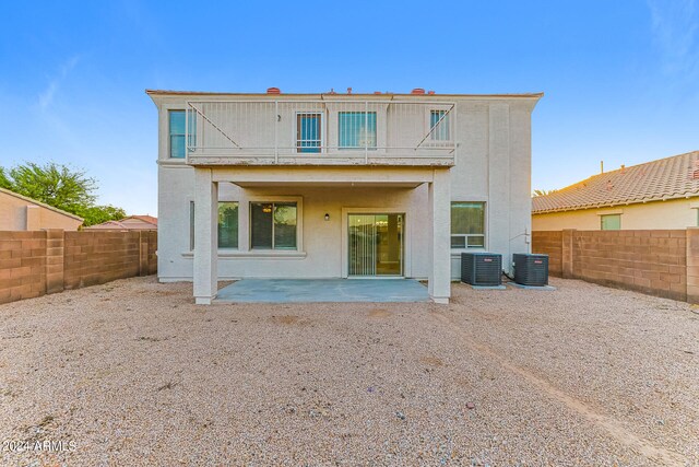 back of property with a patio, central AC unit, and a balcony