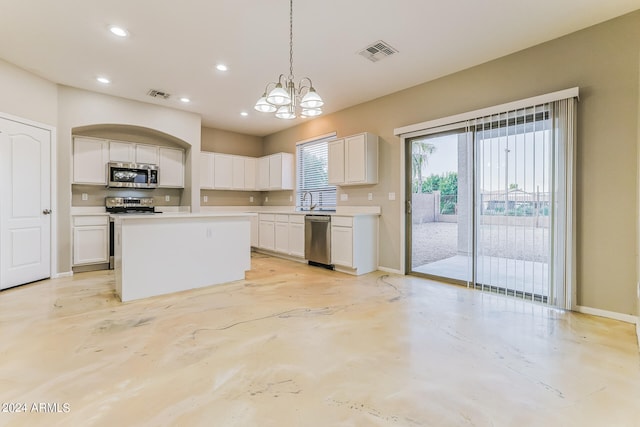 kitchen with a kitchen island, stainless steel appliances, pendant lighting, a chandelier, and white cabinetry