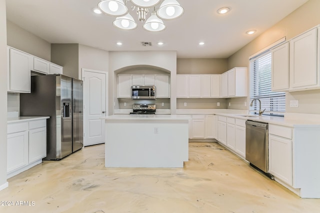 kitchen with white cabinetry, stainless steel appliances, and a kitchen island