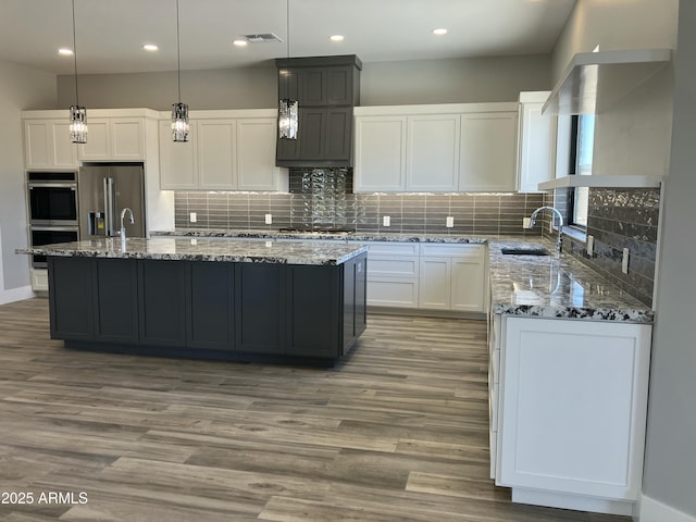 4079 E Roosevelt St, Apache Junction, AZ 85119 - kitchen with appliances with stainless steel finishes, light stone countertops, light wood finished floors, white cabinets, and recessed lighting