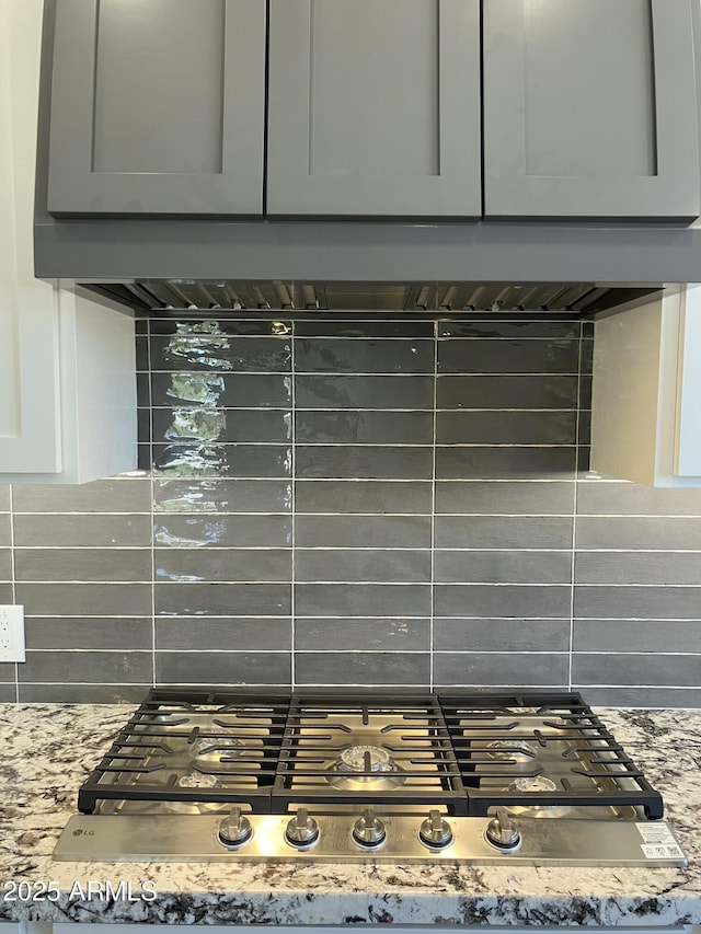 4079 E Roosevelt St, Apache Junction, AZ 85119 - kitchen view of tasteful backsplash, stainless steel gas cooktop, gray cabinetry, and light stone counters