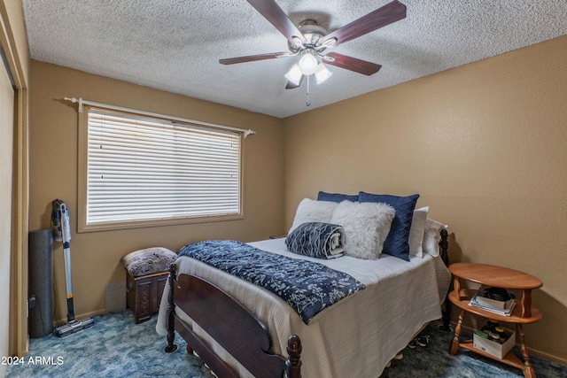 carpeted bedroom with ceiling fan and a textured ceiling