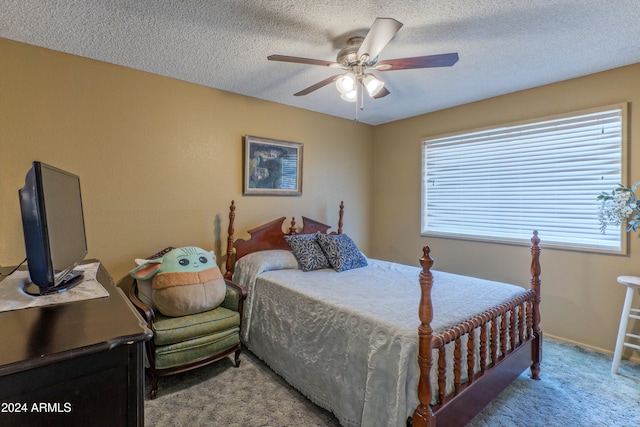 carpeted bedroom featuring ceiling fan and a textured ceiling