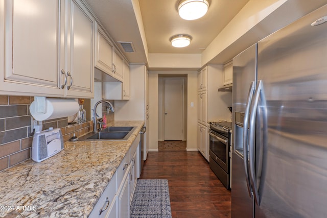 kitchen featuring sink, backsplash, stainless steel appliances, light stone countertops, and dark hardwood / wood-style flooring