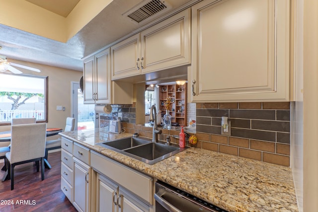 kitchen featuring ceiling fan, dark hardwood / wood-style flooring, light stone counters, sink, and decorative backsplash