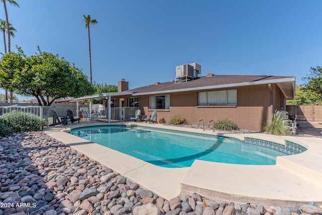 view of swimming pool with cooling unit and a patio