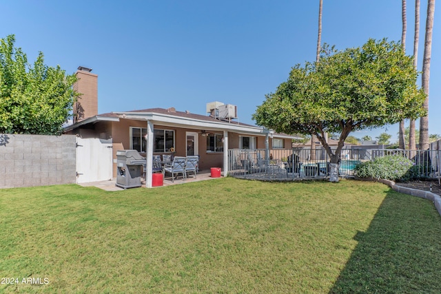 back of property with a lawn and a patio area