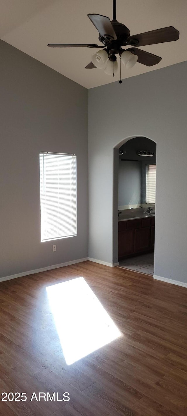 spare room with ceiling fan, vaulted ceiling, and light hardwood / wood-style flooring