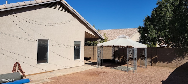 back of house with a gazebo