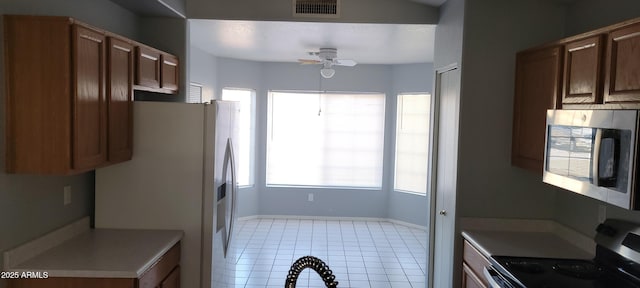 kitchen with stainless steel appliances, ceiling fan, and light tile patterned flooring