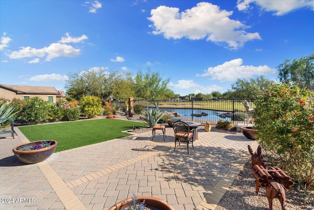 view of patio / terrace featuring an outdoor fire pit, a pool, and a water view