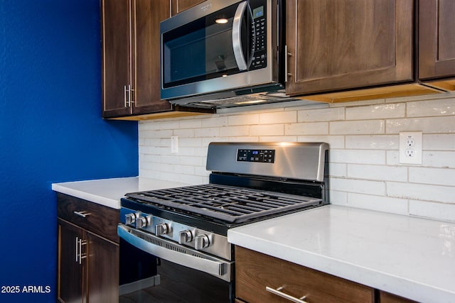 kitchen featuring decorative backsplash, dark brown cabinets, and stainless steel appliances