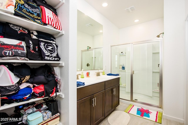 bathroom with tile patterned floors, vanity, and an enclosed shower