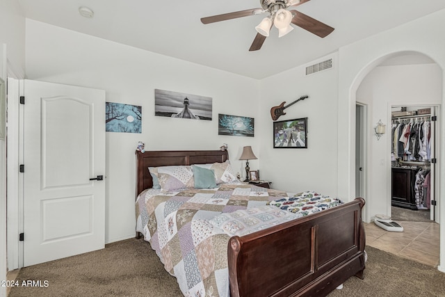 carpeted bedroom featuring a spacious closet, ceiling fan, and a closet